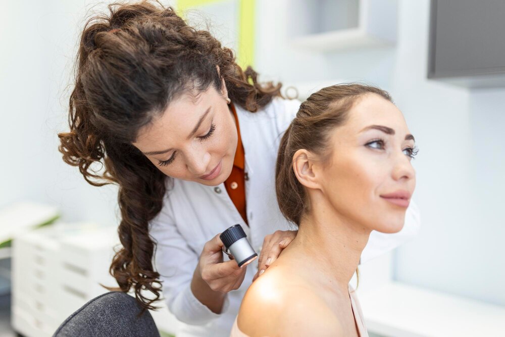 Dermatologist in latex gloves holding dermatoscope while examining attractive patient with skin disease Female dermatologist examining patient with dermascope looking for signs of skin cancer